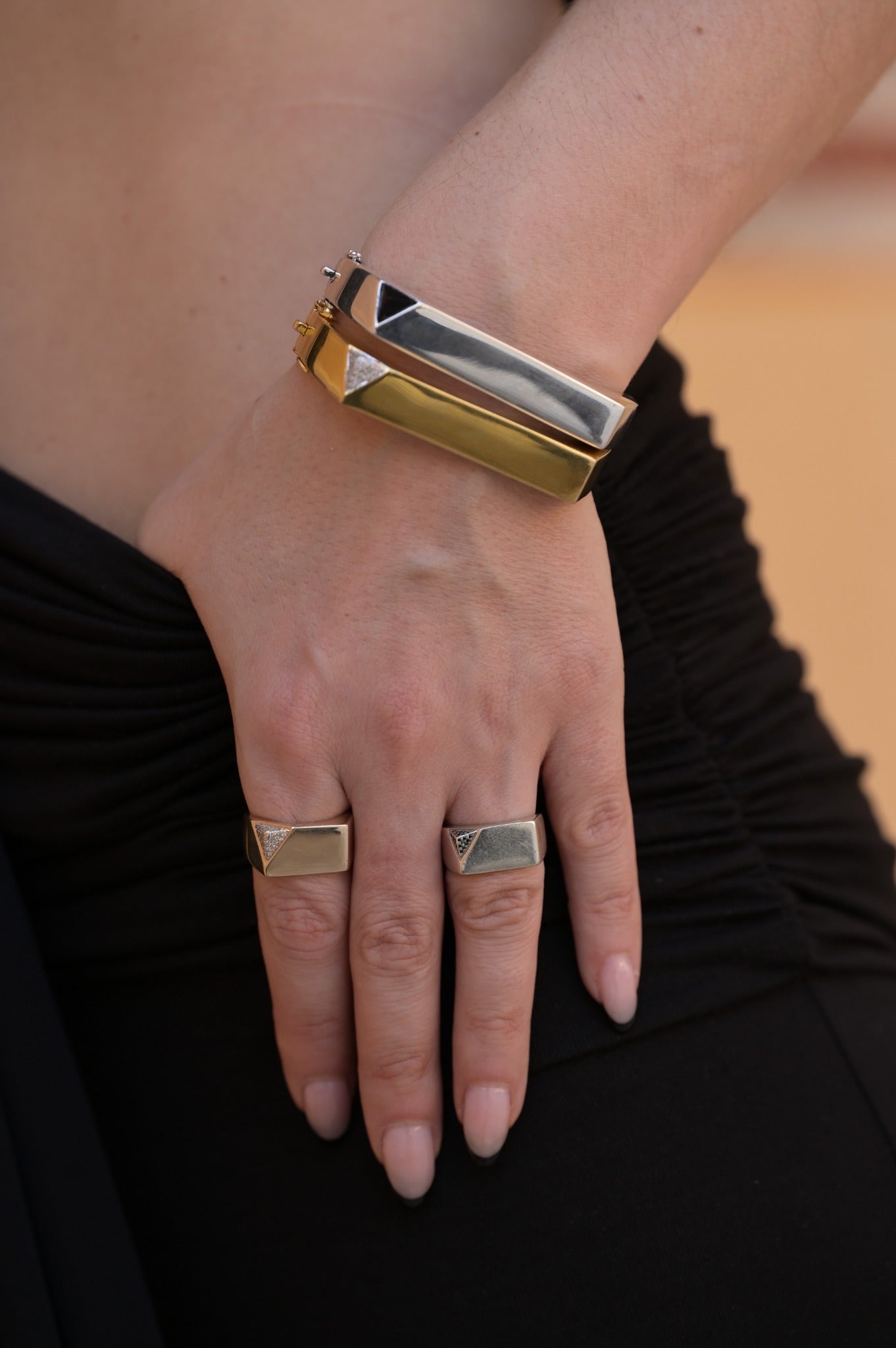 Sculptural cuffs worn with matching signet rings